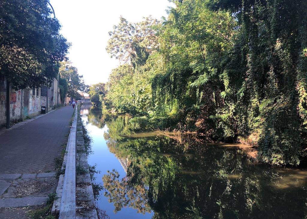 Entlang des Naviglio Martesana lässt sich's gut radeln Ein breiter Kanal nimmt zwei Drittel des Bildes ein. Links davon ein breitet gepflasterter Weg. Rechts säumen Sträucher und Bäume den Naviglio Martesana. Einer meiner Geheimtipps für den nächsten Mailand-Besuch