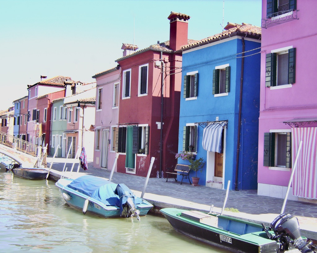 Bunte Häuser Burano Eng nebeneinander stehende farbige Häuser (pink, blau.rostrot, rosa, mint) Davor ein Kanal mit Booten am Ufer auf Burano in der Lagune Venedigs