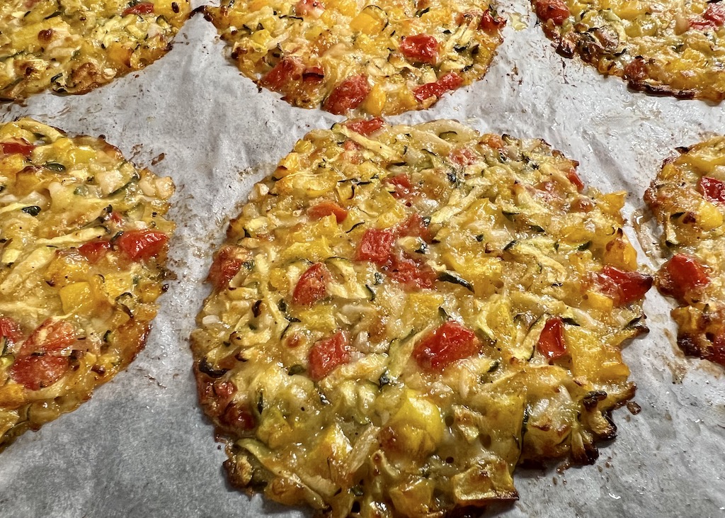 S'anguli 'e cipudda, auch Coccoi genannt S'anguli 'e cipudda - die sardische Pizza. Gebackene handflächengroße S'anguli 'e cipudda liegen nebeneinander auf einem mit Backpapier ausgelegten Backblech